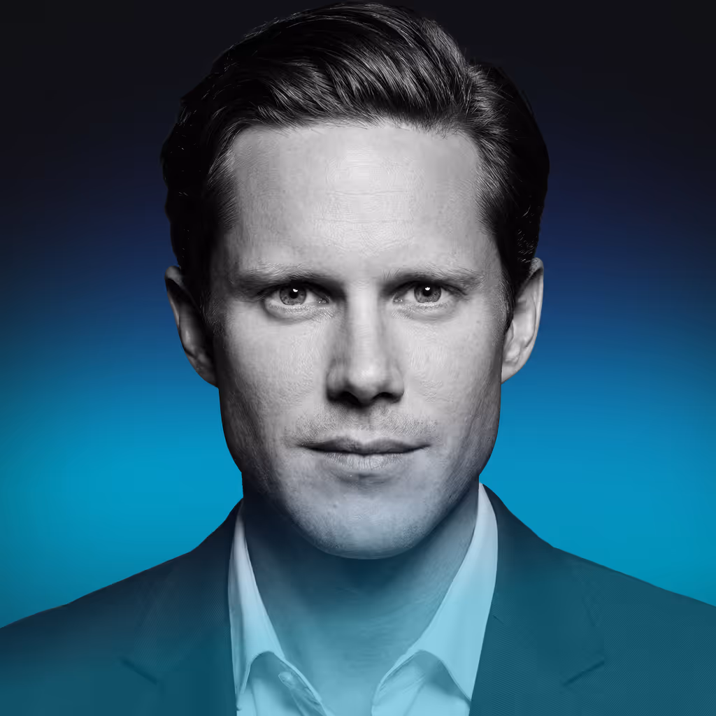 Close-up black and white portrait of a man with neatly combed hair wearing a suit jacket and white shirt against a blue gradient background.